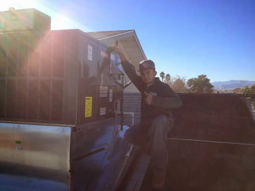 HVAC technician performing Air Duct Cleaning on a rooftop unit in Groveland